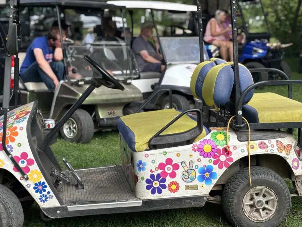 A golf cart decorated with flowers and balloons at the campground