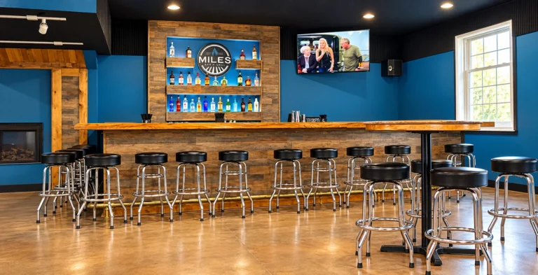 Bar seating and rustic wooden counter inside Miles Bar and Grill