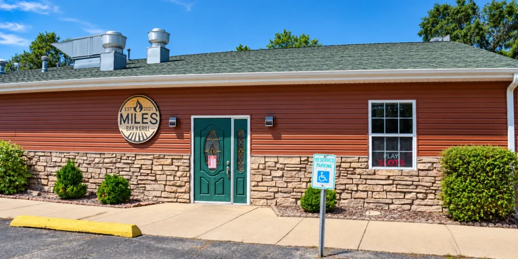 Miles Bar and Grill entrance with green doors and accessible parking