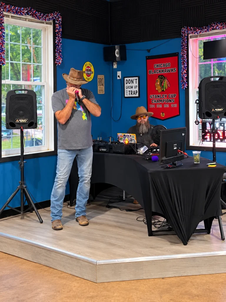 A harmonica performer and sound operator on the indoor stage at Holiday Acres campground